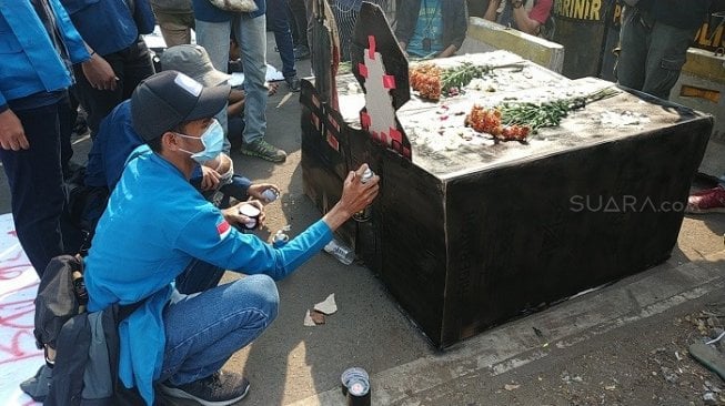 Aksi teatrikal mahasiswa saat demo menolak RKUHP dan UU KPK di sekitar Gedung DPRI, RI Senayan. (Suara.com/Fakhri).