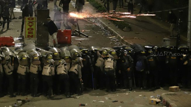 Polisi menembakkan gas air mata untuk membubarkan massa yang rusuh di Jalan Pejompongan, Jakarta Pusat, Senin (30/9). [Suara.com/Arya Manggala]