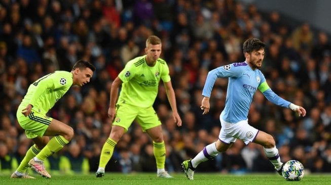 Kapten Manchester City, David Silva, Melewati para pemain Dinamo Zagreb dalam gelaran Liga Champions 2019/20 di Stadion Etihad, Rabu (2/10/2019). [Anthony Devlin / AFP]