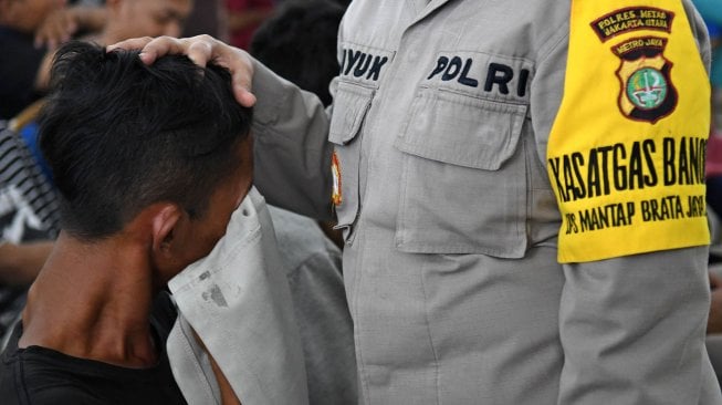 Seorang anak yang terjaring dalam razia pencegahan keterlibatan pelajar dalam aksi unjuk rasa menangis saat akan dipulangkan di Mapolres Jakarta Utara, Jakarta, Rabu (2/10). [ANTARA FOTO/Aditya Pradana Putra]
