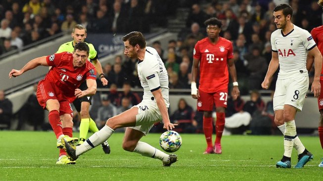 Pemain depan Bayern Muenchen Robert Lewandowski (kiri) menembak melewati bek Tottenham Hotspur Jan Vertonghen untuk mencetak gol kedua mereka selama pertandingan sepak bola Grup B Liga Champions antara Tottenham Hotspur melawan Bayern Muenchen di Stadion Tottenham Hotspur, London, Inggris, Rabu (2/10) dini hari WIB. [Glyn KIRK / IKIMAGES / AFP]
