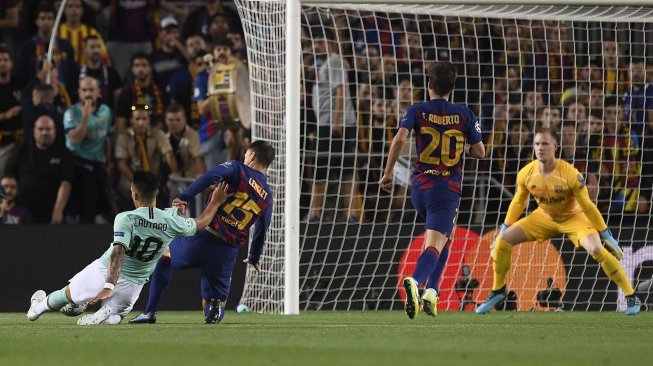 Pemain depan Inter Milan Lautaro Martinez (kiri) menembak untuk mencetak gol selama selama pertandingan sepak bola Grup F Liga Champions  antara Barcelona melawan Inter Milan di Stadion Camp Nou, Barcelona, Spanyol, Kamis (3/10) dini hari WIB. [Josep LAGO / AFP]