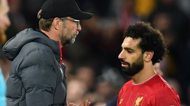 Penyerang Liverpool, Mohamed Salah bersalaman dengan Jurgen Klopp pada gelaran Liga Champions 2019/20, Kamis (3/10/2019). (Paul ELLIS / AFP)