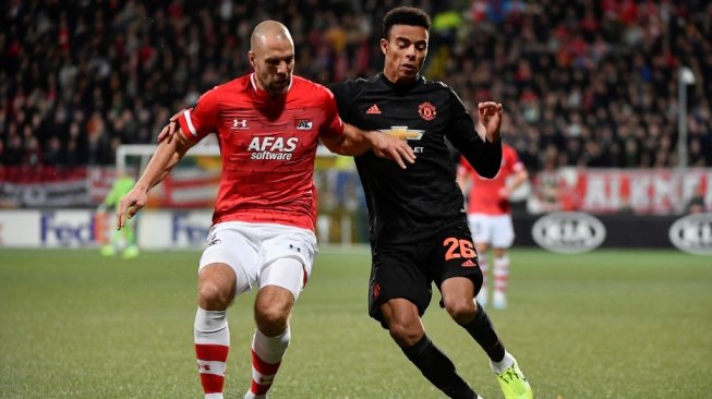 Kapten AZ Alkmaar, Ron Vlaar (kiri) berebut bola dengan penyerang Manchester United, Mason Greenwood pada lanjutan Liga Europa 2019/20 di Stadion Cars Jeans, Den Haag, Kamis (3/10/2019). [JOHN THYS / AFP]