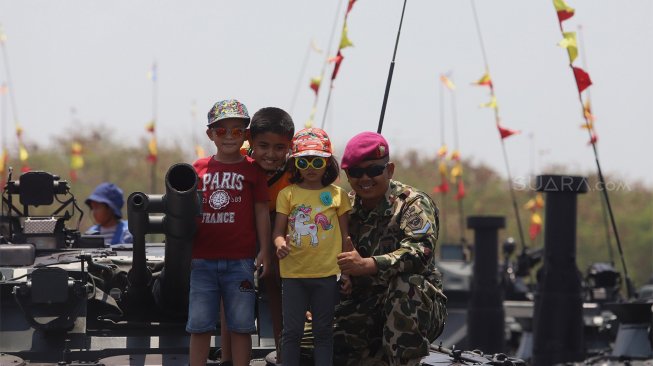 Sejumlah warga menaiki tank milik TNI yang terparkir di Landasan Udara Halim Perdanakusuma, Jakarta Timur, Sabtu (5/10). [Suara.com/Angga Budhiyanto]