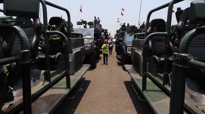 Sejumlah warga menaiki tank milik TNI yang terparkir di Landasan Udara Halim Perdanakusuma, Jakarta Timur, Sabtu (5/10). [Suara.com/Angga Budhiyanto]