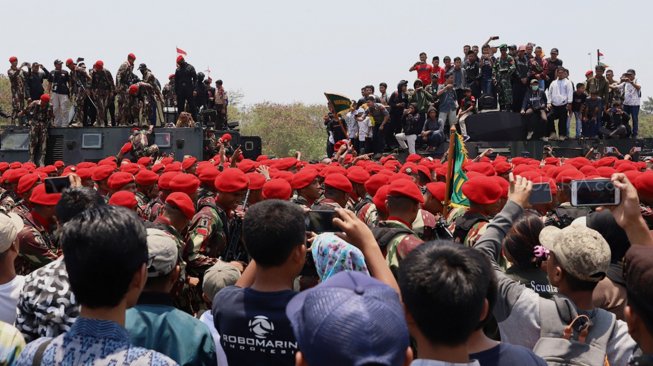 Sejumlah warga menaiki tank milik TNI yang terparkir di Landasan Udara Halim Perdanakusuma, Jakarta Timur, Sabtu (5/10). [Suara.com/Angga Budhiyanto]