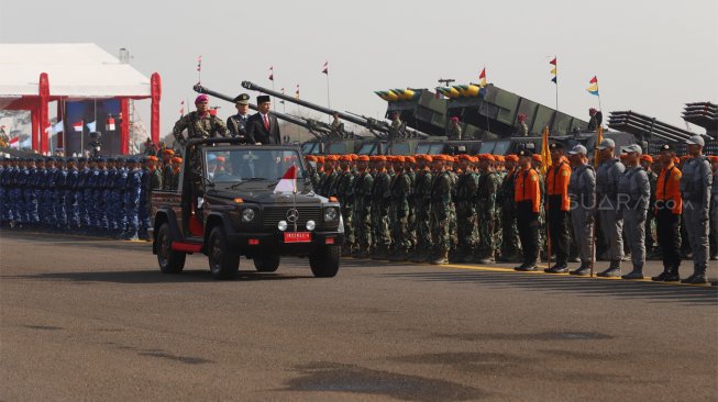 Presiden Joko Widodo (kanan) melakukan inspeksi jajaran pasukan saat Upacara Perayaan HUT Ke-74 TNI di  Taxy Way Echo Landasan Udara Halim Perdanakusuma  , Jakarta Timur, Sabtu (5/10). [Suara.com/Angga Budhiyanto]
