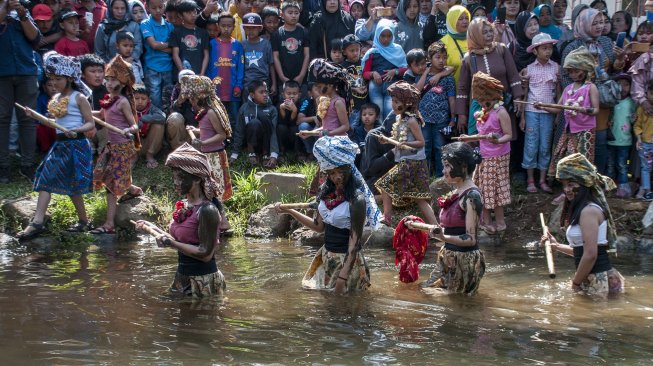 Warga melaksanakan Tradisi Perang Air Upacara Adat Irung Irung Ngalokat Cai Nyalameutkueun Solokan di Desa Cihideung, Kabupaten Bandung Barat, Minggu (6/10). [ANTARA FOTO/Novrian Arbi]