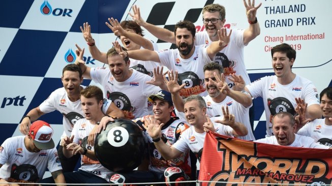 Pebalap Repsol Honda, Marc Marquez, merayakan keberhasilan jadi juara dunia kedelapan bersama timnya pada MotoGP Thailand di Sirkuit Buriram, Minggu (6/10/2019). [AFP/Lillian Suwanrumpha]