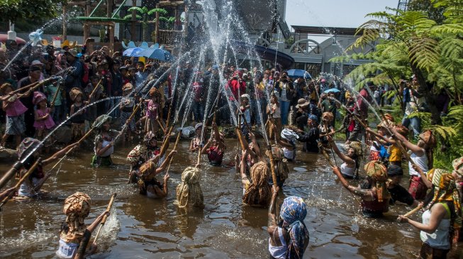 Warga melaksanakan Tradisi Perang Air Upacara Adat Irung Irung Ngalokat Cai Nyalameutkueun Solokan di Desa Cihideung, Kabupaten Bandung Barat, Minggu (6/10). [ANTARA FOTO/Novrian Arbi]