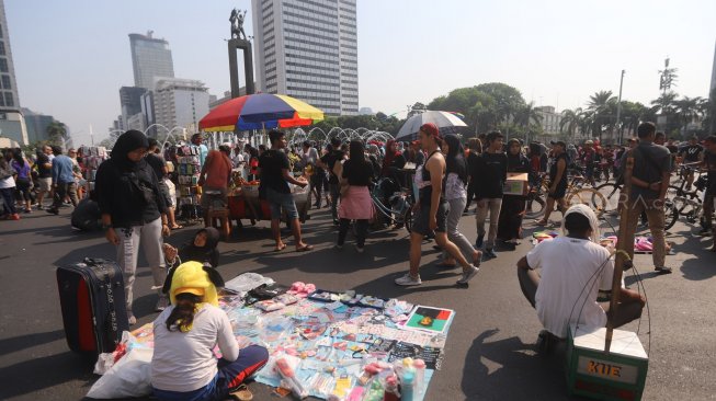 Sejumlah Pedagang Kaki Lima (PKL) berjualan di kawasan Car Free Day (CFD), Bundaran HI, Jakarta, Minggu (6/10). [Suara.com/Arya Manggala]