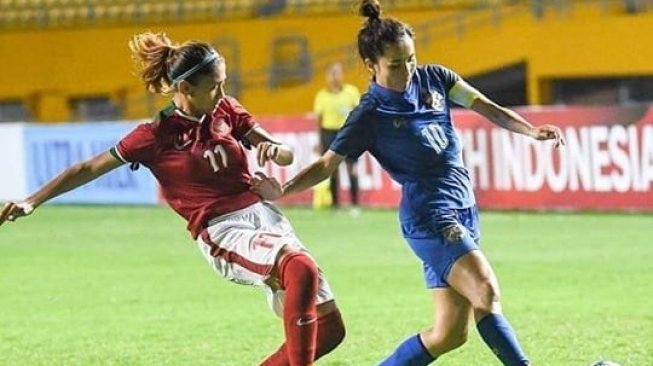 Kapten Timnas Putri Indonesia, Zahra Muzdalifah berebut bola dengan pemain lawan pada salah satu kompetisi sepak bola. (Instagram/@zahmuz12)