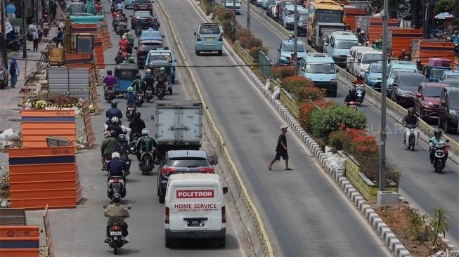 Sejumlah kendaraan melintas di samping proyek galian utilitas terpadu di Jalan Otto Iskandar Dinata, Jakarta Timur, Senin (7/10). [Suara.com/Angga Budhiyanto]