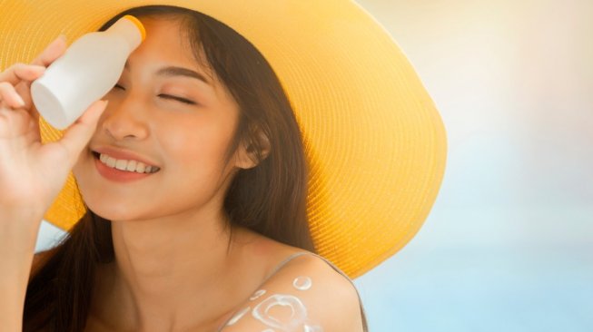 Perempuan menggunakan sunscreen. (Shutterstock)
