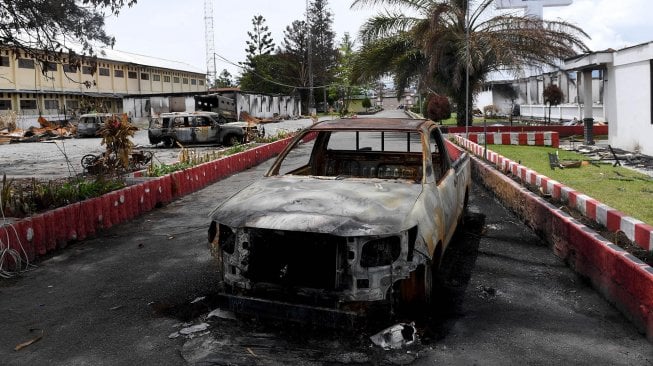 Bangkai mobil yang hangus terbakar di Kantor Bupati Jayawijaya, Wamena, Papua, Rabu (9/10). [ANTARA FOTO/M Risyal Hidayat]