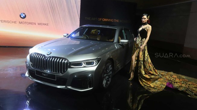 Model berpose di dekat Mobil The New BMW 730Li M Sport dalam peluncuran BMW Seri 7 Long Wheelbase di Jakarta, Kamis (10/10). [Suara.com/Arya Manggala]