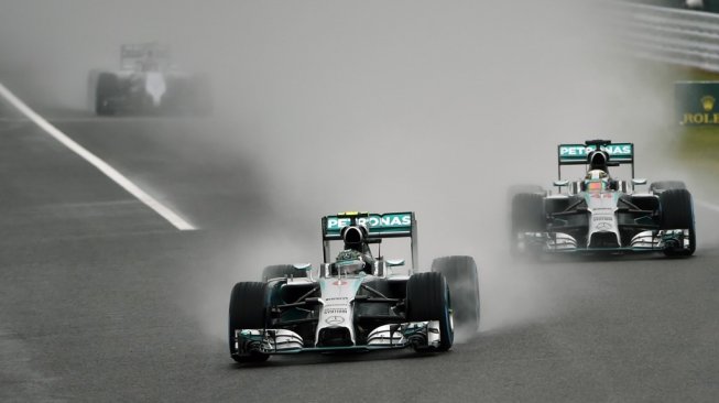 Pebalap Mercedes, Nico Rosberg, memimpin balapan di depan rekan setimnya Lewis Hamilton dalam kondisi lintasan basah pasca diguyur hujan pada balapan F1 GP Jepang di Sirkuit Suzuka, Minggu (5/10/2014). [AFP/ Toshifumi Kitamura]