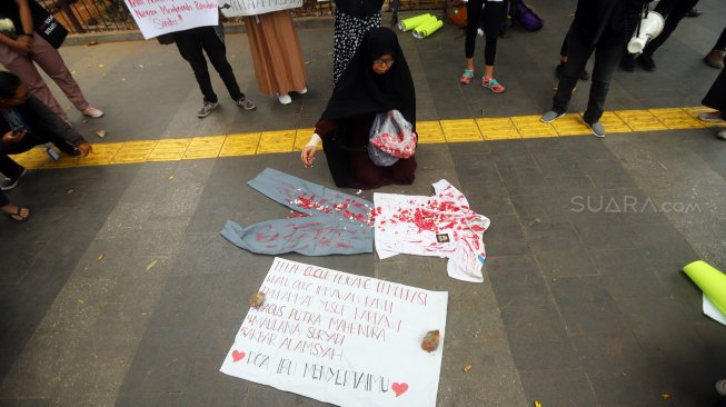 Massa aksi yang tergabung dalam Solidaritas Emak-Emak Indonesia melakukan tabur bunga di depan Polda Metro Jaya, Jakarta, Minggu (13/10). [Suara.com/Arya Manggala]