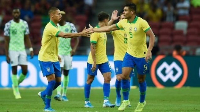 Gelandang Brasil Casemiro (kanan) merayakan golnya ke gawang Nigeria dalam laga persahabatan di National Stadium, Singapore. Roslan RAHMAN / AFP