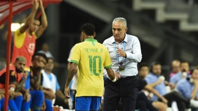Pemain depan Brasil Neymar (kiri) berjabat dengan pelatih Tite setelah mengalami cedera saat menghadapi Nigeria dalam laga persahabatan di National Stadium, Singapore. Roslan RAHMAN / AFP