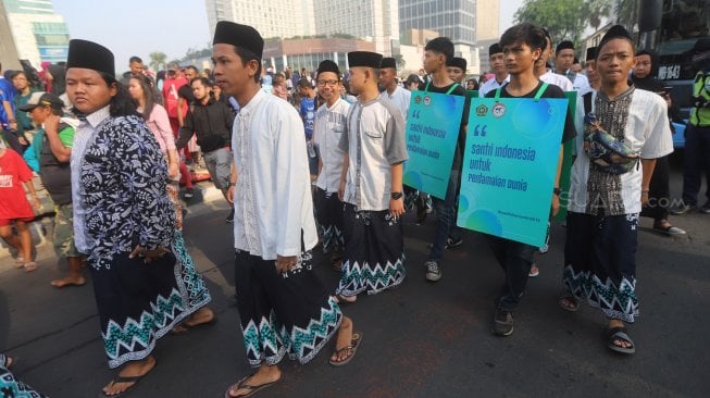 Ratusan santri dari berbagai pesantren mengikuti Parade Santri Cinta Damai saat Car Free Day, Jakarta, Minggu, (13/10). [Suara.com/Arya Manggala]