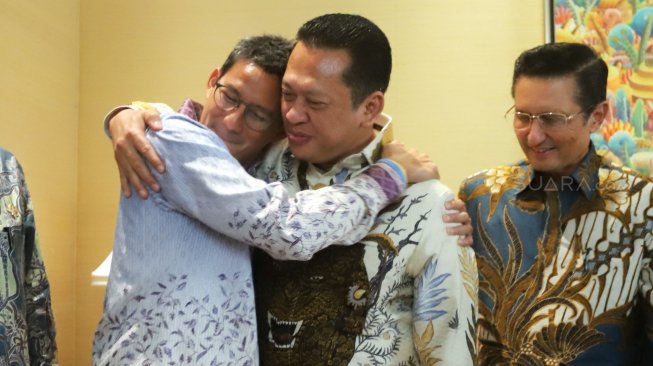 Ketua MPR Bambang Soesatyo (tengah) berpelukan dengan mantan Calon Wakil Presiden Sandiaga Uno (kiri), di Kediaman Sandiaga Uno, kawasan Kebayoran Baru, Jakarta, Senin (14/10). [Suara.com/Arya Manggala]