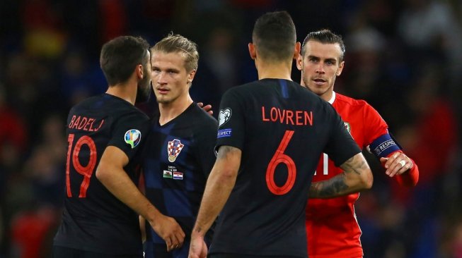 Pemain Timnas Wales bersalaman dengan pemain Kroasia usai laga berakhir dalam lanjutan Kualifikasi Piala Eropa 2020, Senin (14/10/2019). (GEOFF CADDICK / AFP)