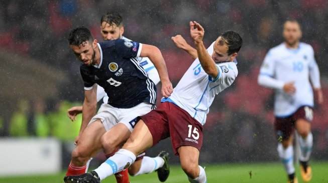 Pemain Timnas San Marino mengganggu pemain Skotlandia dalam lanjutan Kualifikasi Piala Eropa 2020 di Stadion Hampden Park, Minggu (13/10/2019). (ANDY BUCHANAN / AFP)