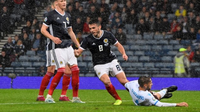 Penyerang Skotlandia, John McGinn (tengah) merayakan gol ketiganya saat mengahadapi Timnas San Marino dalam lanjutan Kualifikasi Piala Eropa 2020 di Stadion Hampden Park, Minggu (13/10/2019). (ANDY BUCHANAN / AFP)