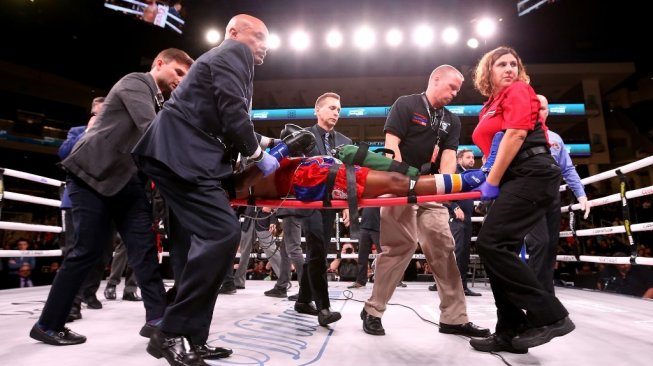 Petinju AS, Patrick Day, ditandu ke luar ring usai dipukul KO lawannya Charles Conwell dalam pertarungan kelas welter super USBA di Wintrust Arena, Chicago, Sabtu (12/10/2019). [AFP/Dylan Buell]