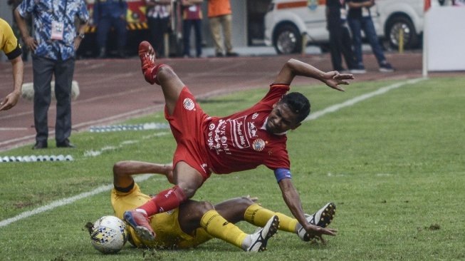 Pesepak bola Persija Jakarta Ramdani Lestaluhu (kanan) berebut bola dengan Pesepak bola Semen Padang FC Vanderley (bawah) pada lanjutan Liga 1 di Stadion Patriot Chandrabahaga, Bekasi, Jawa Barat, Rabu (16/10/2019). Babak pertama berakhir 1-0 untuk Persija Jakarta. ANTARA FOTO/Fakhri Hermansyah/foc.