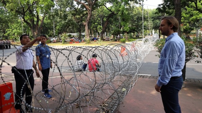 Suasana penutupan Jalan Medan Merdeka Barat, Jakarta, Kamis (17/10). [Suara.com/Angga Budhiyanto]
