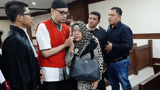 Sandy Tumiwa bersama sang ibu yang menangis, usai divonis empat tahun penjara di Pengadilan Negeri Jakarta Pusat, Kamis (17/10/2019). [Yuliani/Suara.com]