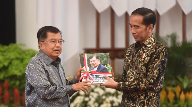 Presiden Joko Widodo (kanan) menerima buku memori jabatan dari Wakil Presiden Jusuf Kalla (kiri) dalam acara silaturahmi kabinet kerja di Istana Negara, Jakarta, Jumat (18/10). [ANTARA FOTO/Akbar Nugroho Gumay]