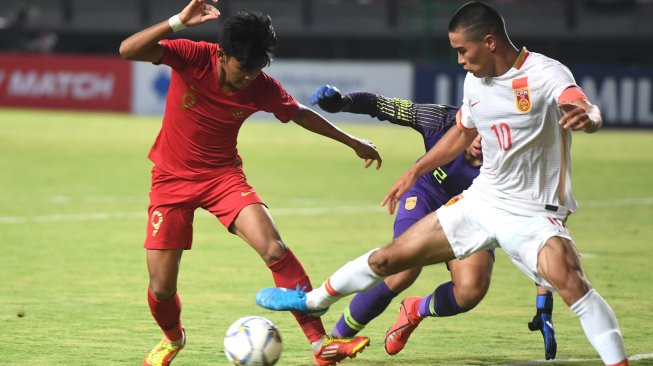 Pesepak bola Indonesia U-19 Sutan Diego Armando Zico (kiri) berebut bola dengan pesepak bola China U-19 Mohemaiti Naibijiang (kanan) dan pejaga gawang Zihaq Huang (tengah) saat laga uji coba di Gelora Bung Tomo, Surabaya, Jawa Timur, Kamis (17/10). [ANTARA FOTO/Zabur Karuru]