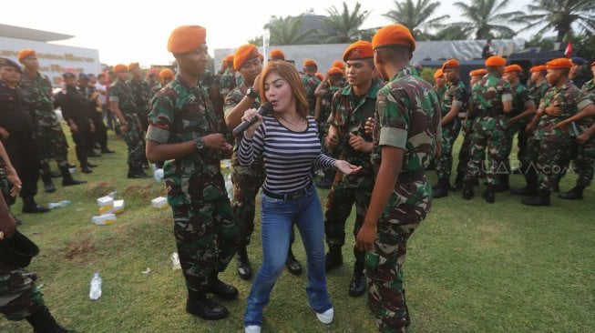 Penyanyi dangdut Irma Darmawangsa menghibur anggota TNI-Polri di halaman Gedung DPR RI, Jakarta, Jumat (18/10). [Suara.com/Arya Manggala]
