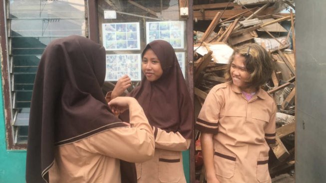 Murid SLB tipe C Pariwisata Bundaku berada di depan ruangan sekolah yang atapnya roboh beberapa waktu lalu. [Suara.com/M Yacub]