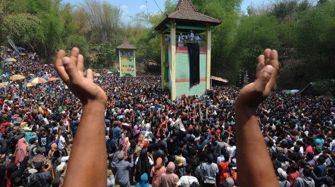 Sejumlah warga menanti kue apem yang disebar saat tradisi Sebar Apem Yaqowiyu di Jatinom, Klaten, Jawa Tengah, Jumat (18/10). [ANTARA FOTO/Aloysius Jarot Nugroho]