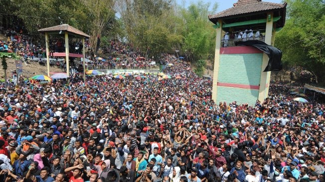 Sejumlah warga menanti kue apem yang disebar saat tradisi Sebar Apem Yaqowiyu di Jatinom, Klaten, Jawa Tengah, Jumat (18/10). [ANTARA FOTO/Aloysius Jarot Nugroho]