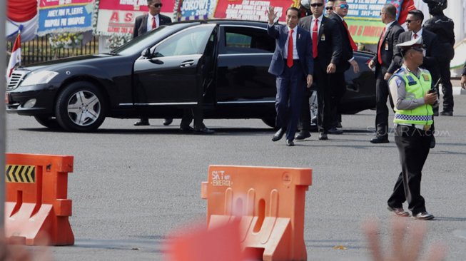 Presiden Joko Widodo menyapa para pendukungnya di Jalan Merdeka Barat, Jakarta, Minggu (20/10). [Suara.com/Angga Budhiyanto]