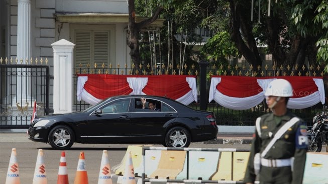 Presiden Joko Widodo menyapa para pendukungnya di Jalan Merdeka Barat, Jakarta, Minggu (20/10). [Suara.com/Angga Budhiyanto]