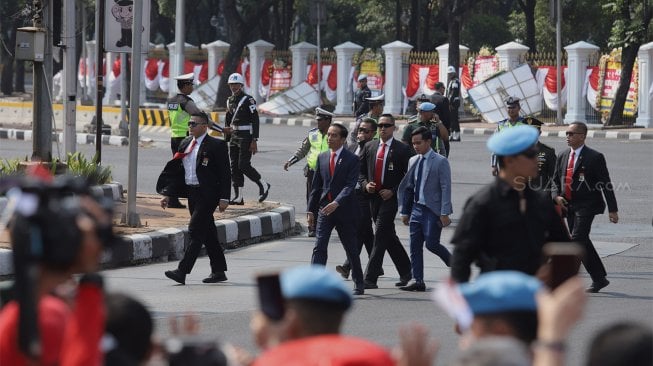 Presiden Joko Widodo menyapa para pendukungnya di Jalan Merdeka Barat, Jakarta, Minggu (20/10). [Suara.com/Angga Budhiyanto]