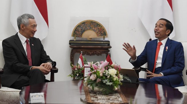 Presiden Joko Widodo (kanan) berbincang dengan Perdana Menteri Republik Singapura Lee Hsien Loong dalam kunjungan kehormatan di Istana Merdeka, Jakarta, Minggu (20/10). [ANTARA FOTO/Puspa Perwitasari]
