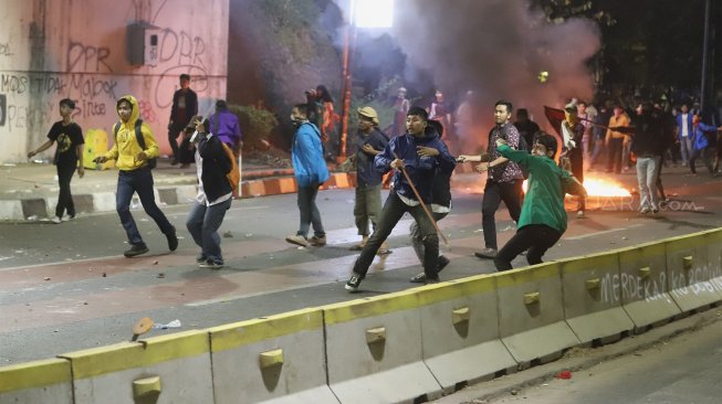 Suasana kericuhan yang terjadi di depan gedung DPR RI, Jakarta, Selasa (24/9). (Suara.com/Angga Budhiyanto)