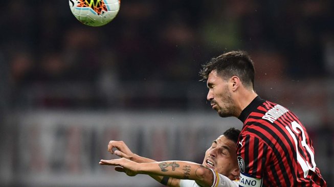 Bek AC Milan Alessio Romagnoli dan pemain depan Lecce Filippo Falco melakukan sundulan selama pertandingan sepak bola Serie A Italia AC Milan melawan Lecce di Stadion San Siro, Milan, Italia, Senin (21/10) dini hari WIB. [Miguel MEDINA / AFP]