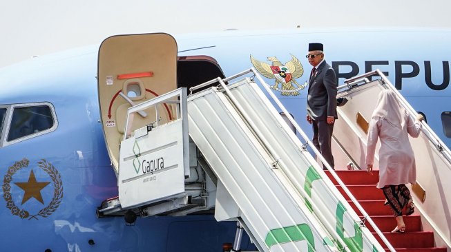 Wakil Presiden Ma'ruf Amin (kiri) didampingi istri Wuri Estu Handayani Ma'ruf Amin (kanan) menaiki tangga Pesawat Kepresidenan di Lanud Halim Perdanakusuma, Jakarta, Senin (21/10). [ANTARA FOTO/Aprillio Akbar]