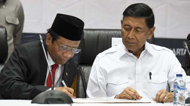 Menko Polhukam Mahfud MD (kiri) bersama mantan Menko Polhukam Wiranto menandatangani berita acara serah terima jabatan di kantor Kemenko Polhukam, Jakarta, Rabu (23/10). [ANTARA FOTO/Hafidz Mubarak]