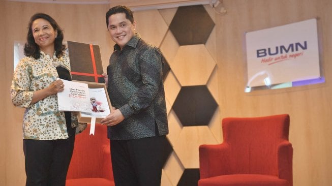 Menteri BUMN Erick Thohir (kanan) menerima buku laporan lima tahunan Kementerian BUMN dari mantan Menteri BUMN Rini Soemarno, saat serah terima jabatan di Kementerian BUMN, Jakarta, Rabu (23/10). [ANTARA FOTO/Akbar Nugroho Gumay]
