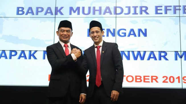 Mendikbud Nadiem Makarim berjabat tangan dengan Menko PMK yang juga mantan Mendikbud Muhadjir Effendy saat acara Lepas Sambut di Kemendikbud, Jakarta, Rabu (23/10). [Suara.com/Arya Manggala]